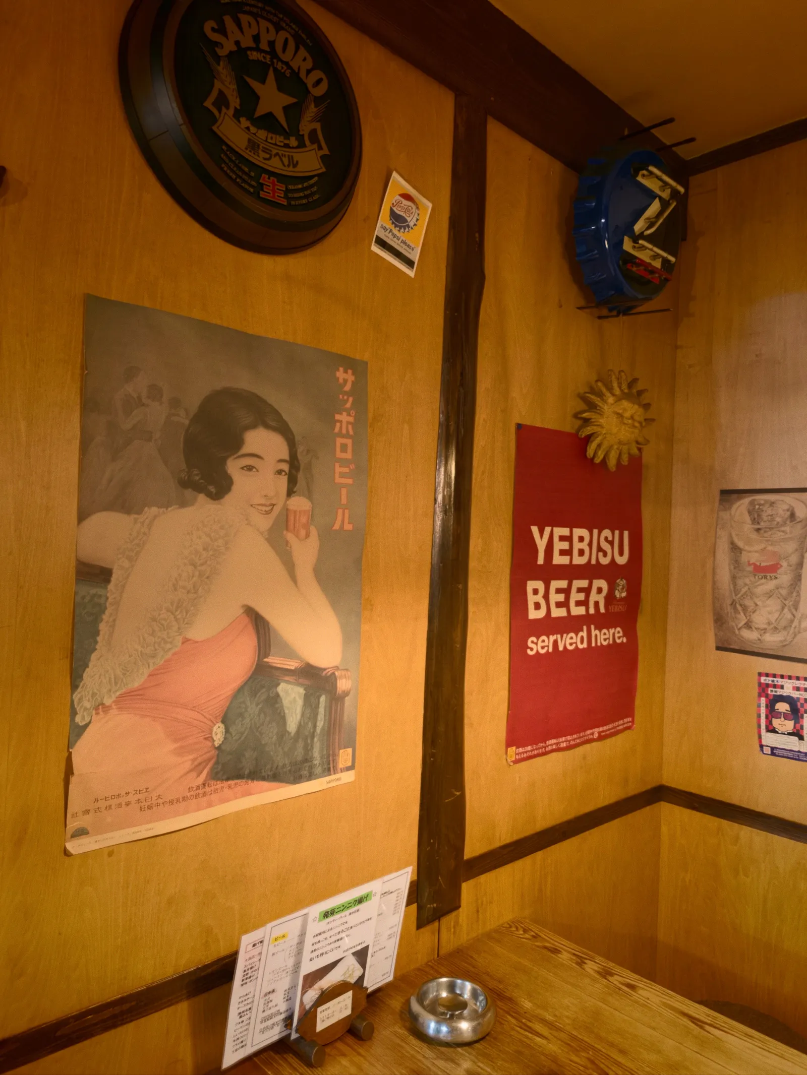 店内に飾られた古いサッポロビールの美人ポスターとYEBISU BEERの赤い旗